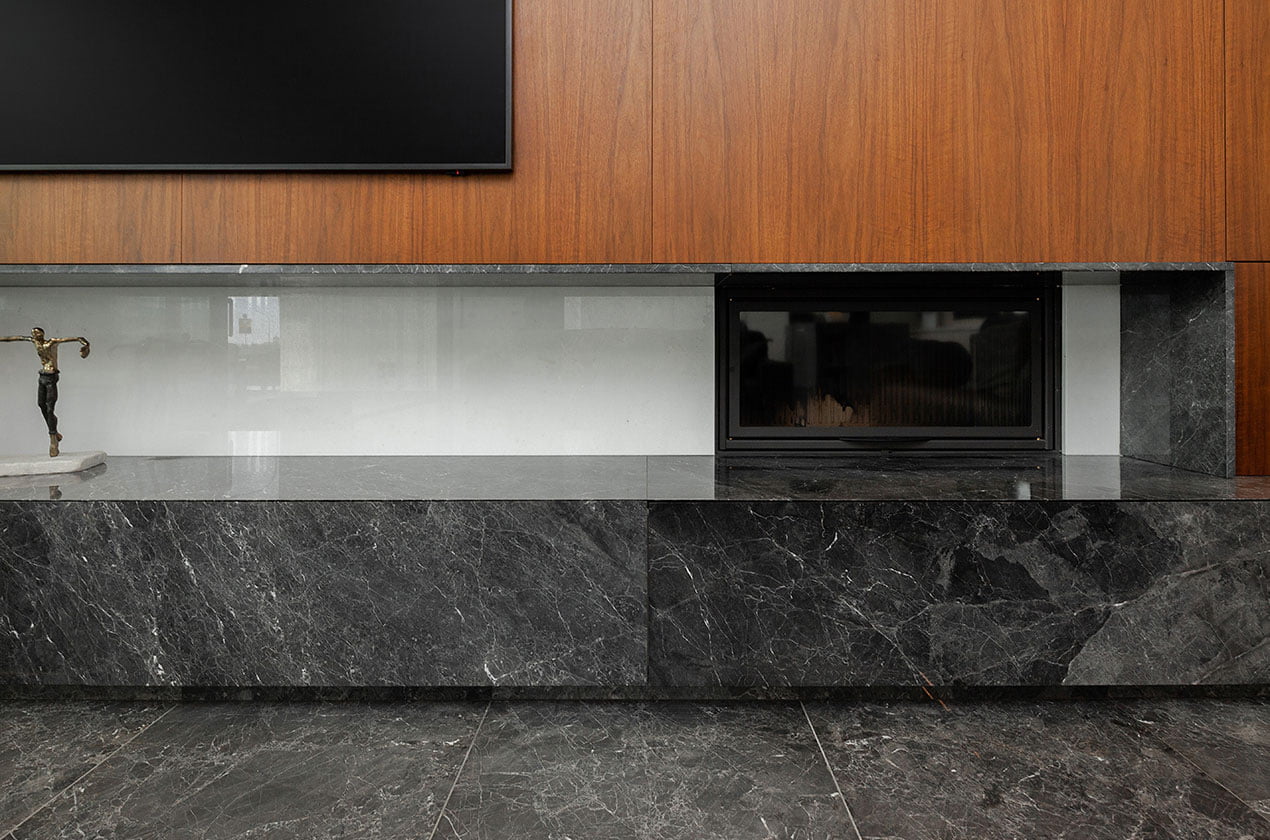 Black marble argos fireplace with wooden panel closeup
