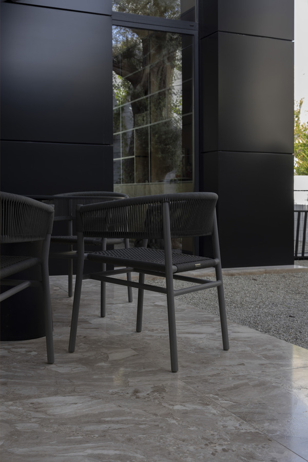 Outdoor seating area with Karnis marble and black chairs.