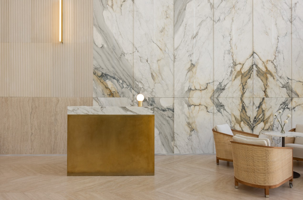 Lobby interior with Travertino fishbone flooring and Calacatta Oro marble walls.